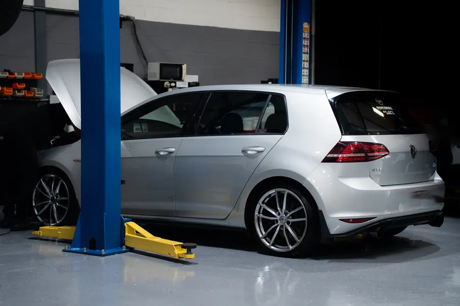 A Volkswagen Golf up on a lift for inspection