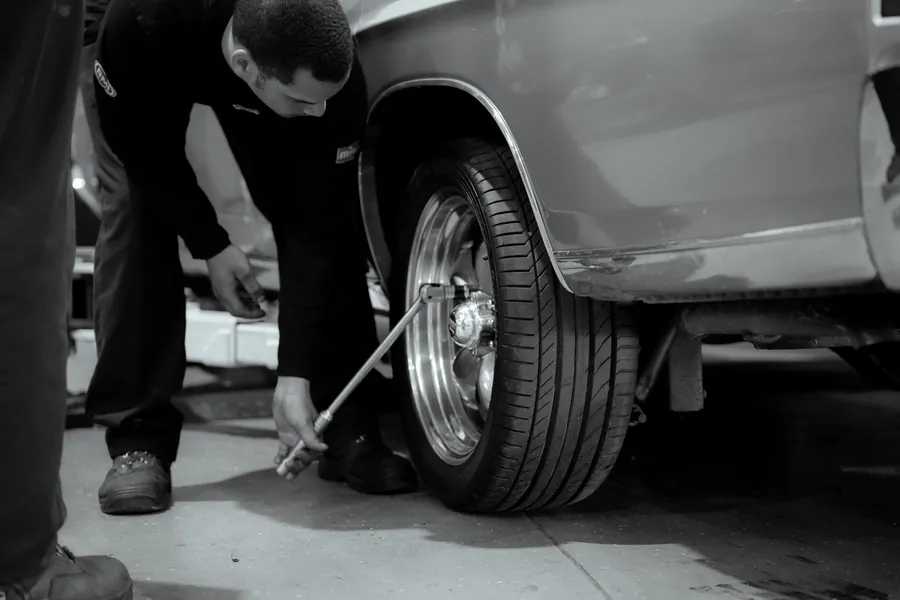 A technician fitting a wheel in the workshop